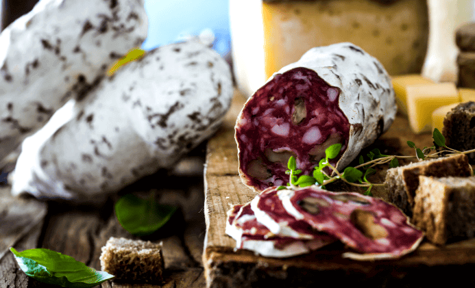 Une planche avec du saucisson, du pain et du fromage